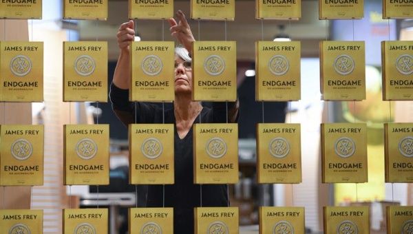 Una empleada alinea los ejemplares del libro del estadounidense James Frey "Endgame" en la Feria del Libro de Fráncfort. (Foto: EFE)