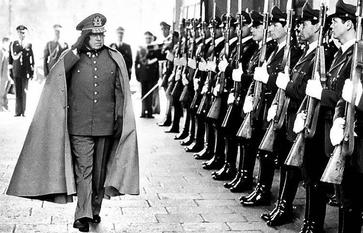 Former Chilean dictator General Augusto Pinochet reviews troops as he enters La Moneda Palace in the capital Santiago.