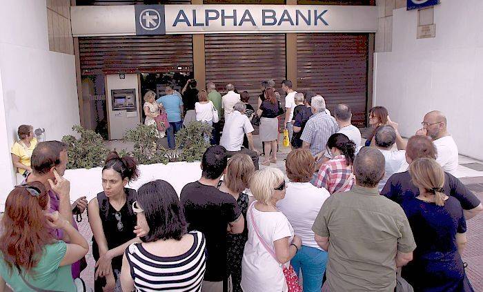 Decenas de personas hacen cola para sacar dinero en un banco en Atenas