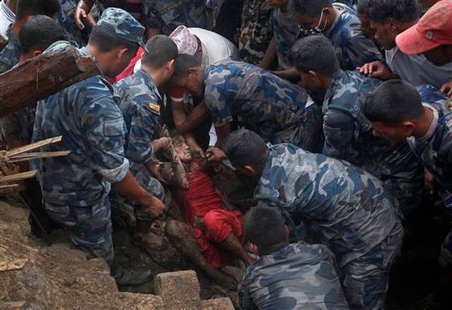 Policías y equipos de rescate del ejército excavan entre pilas de escombros en busca de víctimas.