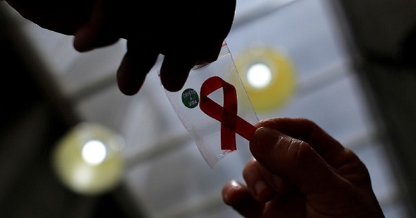 Nurse gives a red ribbon to a woman to mark World Aids Day at the entrance of Emilio Ribas Hospital, in Sao Paulo.