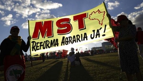 MST activists hold a sign in Brasilia demanding "agrarian reform now!"