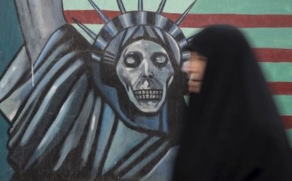 An Iranian woman walks past an anti-U.S. mural painted on the wall of the former U.S. Embassy in Tehran.