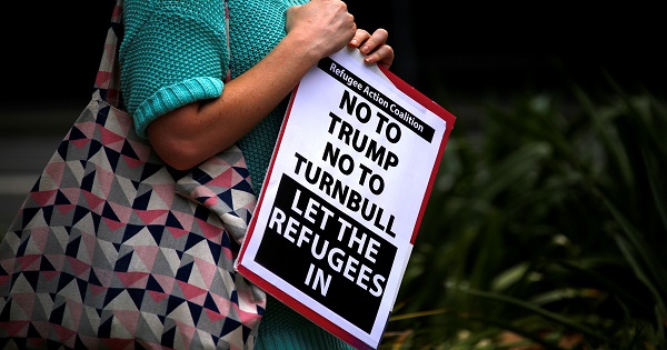 A protester holds a placard in Sydney during one of several rallies across Australia condemning Donald Trump's order temporarily barring refugees.