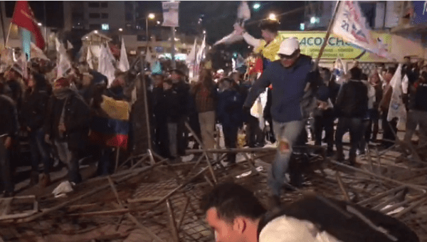Guillermo Lasso supporters break down police barricades.