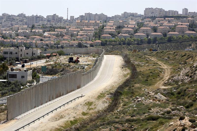 Un muro separa la localidad palestina de Hizma (i) y el barrio judío de Pisgat Ze'ev (d), en Jerusalén (Israel) .
