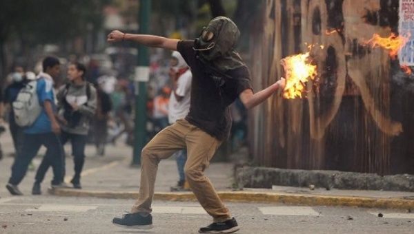 A right-wing opposition demonstrator throws a molotov cocktail during what the Western media has described as peaceful protests.