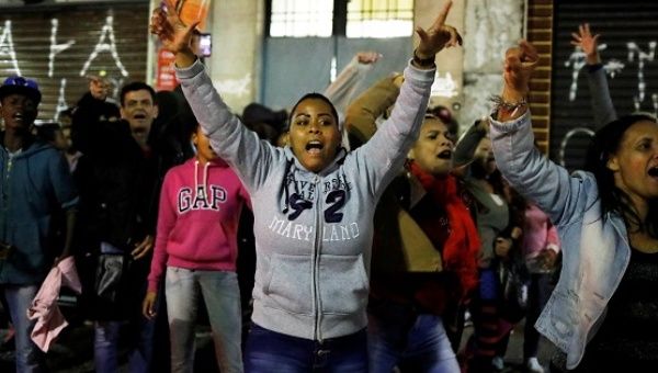 Members of Brazil's Movimento dos Sem-Teto (Roofless Movement) shout slogans as they try open the front door of a vacant building in Sao Paulo.