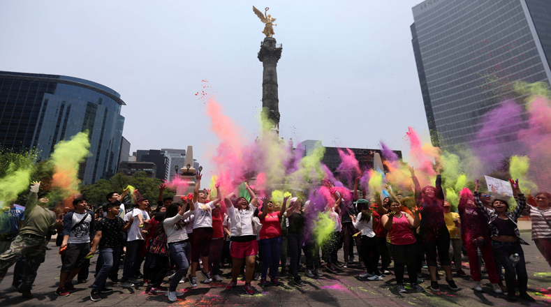 Manifestantes lanzaron al aire polvos de colores contra las semillas y agroquímicos de la compañía estadounidense en el ángel de la Independencia,en la Ciudad de México.