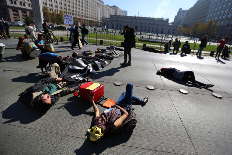 Demonstrators pretending to be dead lie on the ground during a protest against seeds company Monsanto in Santiago, Chile, May 20, 2017. 