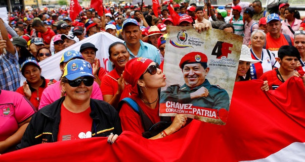 A pro-government supporter holds up a sign of Venezuela's late President Hugo Chavez during a rally of members of the education sector in Caracas, Venezuela June 14, 2016.