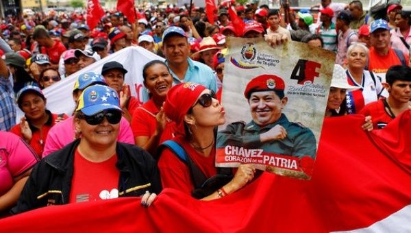 A pro-government supporter holds up a sign of Venezuela's late President Hugo Chavez during a rally of members of the education sector in Caracas, Venezuela June 14, 2016.
