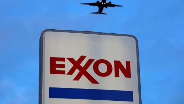 An airplane comes in for a landing above an Exxon sign at a gas station in the Chicago suburb of Norridge, Illinois, Oct. 27, 2016. 
