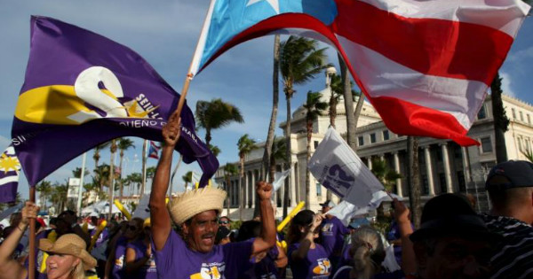 A member of a labor union shouts slogans while holding a Puerto Rico flag during a protest against austerity plans.
