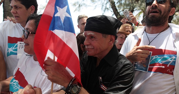 Puerto Rican Oscar Lopez Rivera (C) carries a national flag as he meets with supporters after being released from house arrest May 17, 2017.