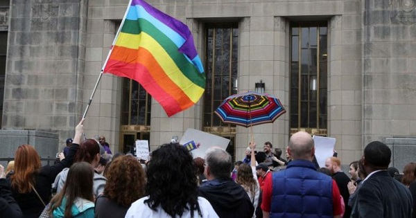 Supporters of same-sex marriage hold a rainbow flag and umbrella outside Jefferson County Courthouse in Birmingham, Alabama, Feb. 9, 2015.