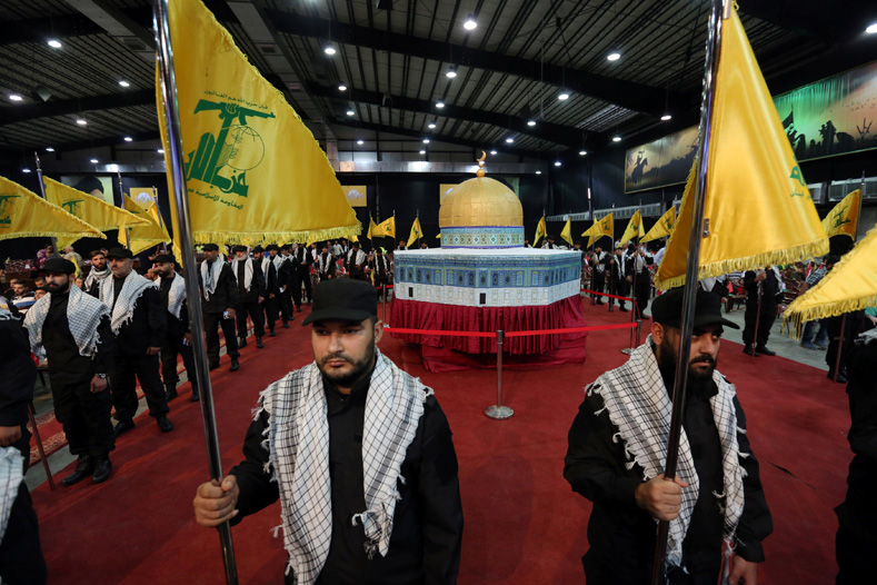Hezbollah members carry Hezbollah flags as they stand in front of a replica of the Dome of the Rock during a rally marking Al-Quds day in Beirut's southern suburbs, Lebanon June 23, 2017. 