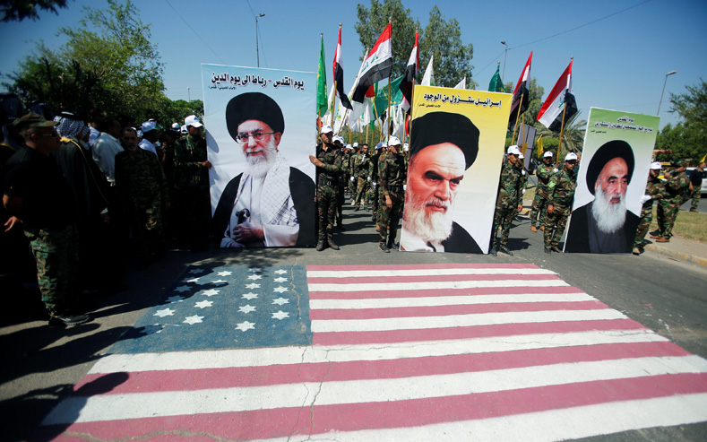 Iraqi Shi'ite Muslims from Hashid Shaabi (Popular Mobilization) hold portraits of Iran's late leader Ayatollah Ruhollah Khomeini (C), Supreme Leader Ayatollah Ali Khamenei (L) and Iraq's top Shi'ite cleric Grand Ayatollah Ali al-Sistani during a parade marking the annual al-Quds Day, or Jerusalem Day, during the Muslim holy month of Ramadan in Baghdad, Iraq June 23, 2017. 