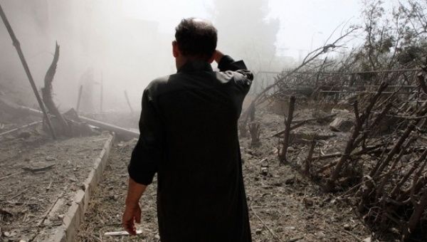 A man walks through rubble in Eastern Syria.