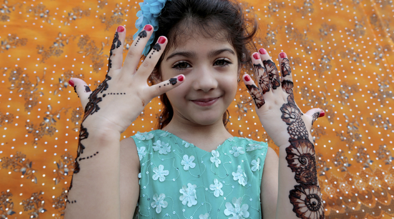 Niñas en Pakistán se realizan tatuajes de henna para decorar sus manos y brazos, para marcar el fin del mes de Ramadán.
