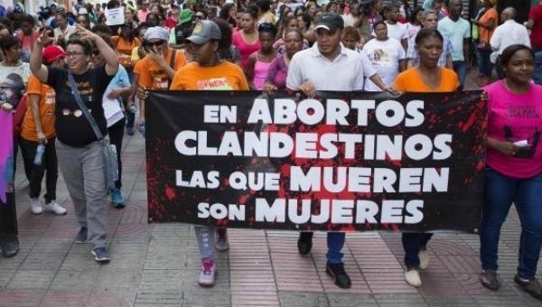 Women protest against the Dominican Republic's abortion ban with a banner that reads, 