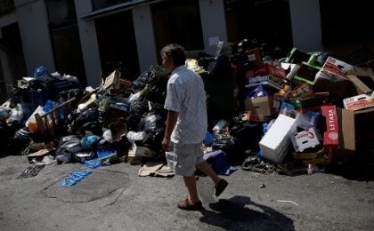 A man walks past a pile of garbage in Piraeus, near Athens, Greece, on June 26, 2017.