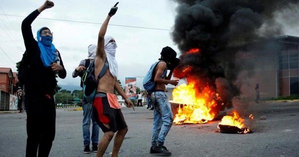 Opposition supporters shout as they burn tires during a protest to demand a referendum to remove President Nicolas Maduro in San Cristobal, Venezuela, May 18, 2016.