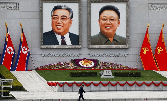 A man walks in front of portraits of North Korea founder Kim Il Sung and late leader Kim Jong Il in central Pyongyang
