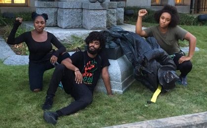 Residents pose with toppled Confederate soldier statue.