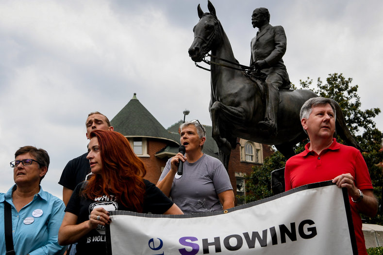 Protesters stand in from of a statue of Confederate Major John B. Castleman in Louisville, demanding that it be removed.