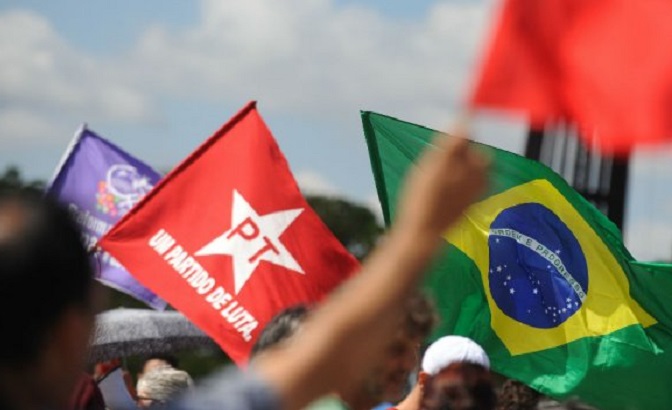 Protesters wave Workers Party and National flags during a demonstration against unelected president Michel Temer.