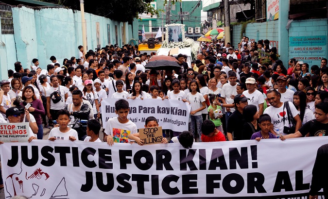 Mourners display a streamer during a funeral march for Kian delos Santos in Caloocan, Metro Manila, Philippines, on August 26, 2017.