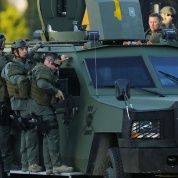 San Bernardino SWAT police riding on a Lenco Bearcat armored vehicle.