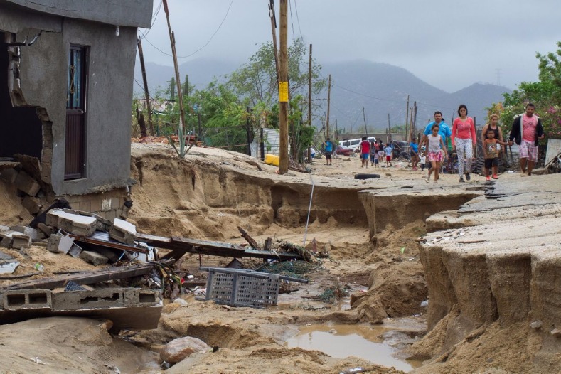 Residents walk along a damaged street in the aftermath of Tropical Storm Lidia in Los Cabos, Mexico.