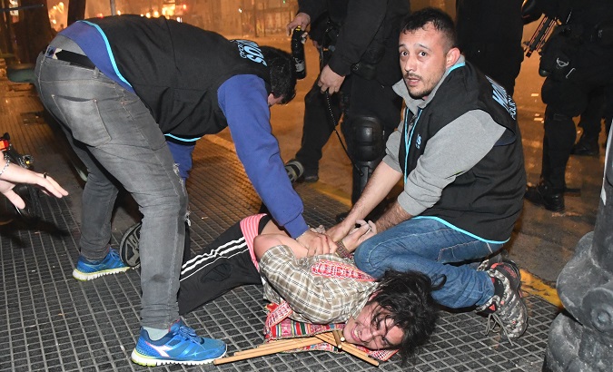 Argentine police arrest a protester during a march in Buenos Aires demanding the appearance of Santiago Maldonado.