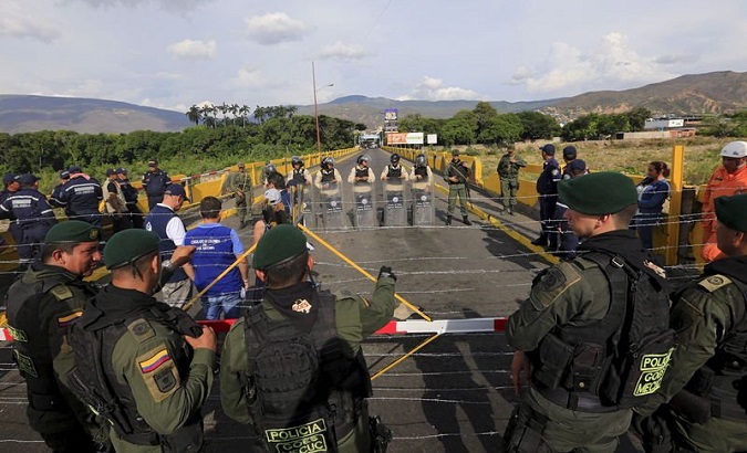Colombian policemen stand guard in front of the border with Venezuelan policemen near Villa del Rosario village.