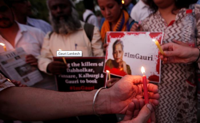 People hold placards and candles during a vigil for Gauri Lankesh in New Delhi.