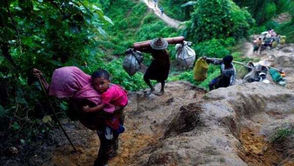 Rohingya refugees climb up a hill after crossing the Bangladesh-Myanmar border in Cox's Bazar.