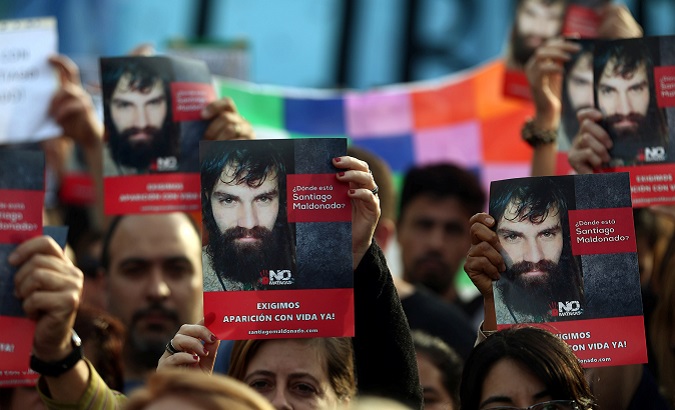 People holds up portraits of Santiago Maldonado, a protester who has been missing since security forces clashed with indigenous activists in Patagonia.