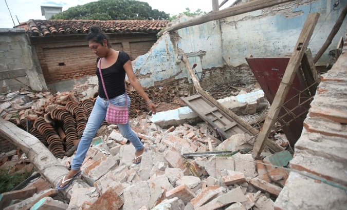 Peregrina Vera, an Zapotec muxe walks on the debris of her house destroyed after an earthquake in Juchitan, Mexico.