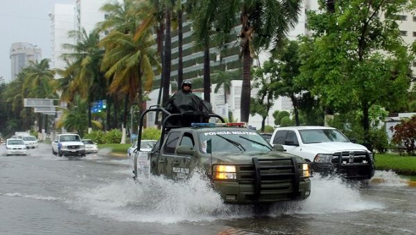 A soldier stands guard atop a vehicle along the street, while Tropical Storm Max approaches Acapulco, Mexico, September 14, 2017