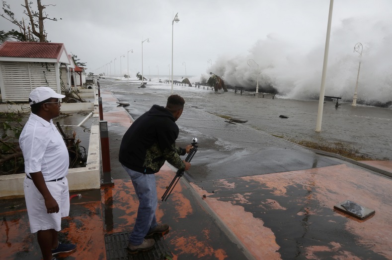 A man takes a video in a flooded seafront in Basse-Terre, Guadeloupe.