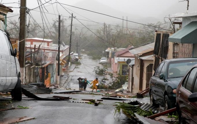 People survey the debris after the streets were hit by Hurricane Maria's winds and rains in Guayama, Puerto Rico