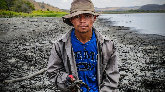 A Nicaraguan fisherman is pictured next to a lake.