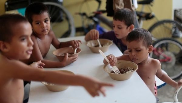 Honduran children eat at the Todo por Ellos shelter in Tapachula.