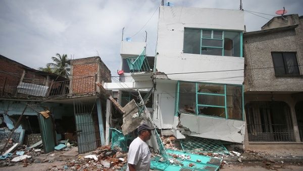 A man walks past houses destroyed after the earthquake, in Jojutla de Juarez, Mexico.
