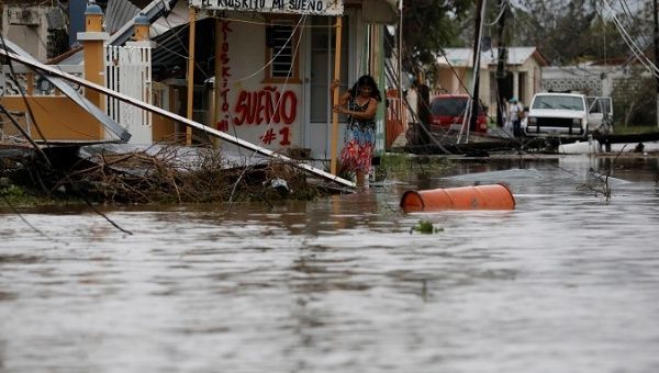 A woman tries to walks out from her house after the area was hit by Hurricane Maria in Salinas, Puerto Rico.