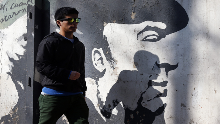 Un hombre pasa por delante de un grafiti del poeta en Santiago de Chile.