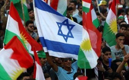 Iraqi Kurds fly an Israeli flag and Kurdish flags during an event to urge people to vote in the upcoming independence referendum.