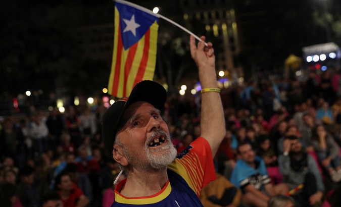 A man waves an Estelada as people gather at Plaza Catalunya after voting ended for the banned independence referendum in Barcelona, Spain, Oct. 1, 2017.